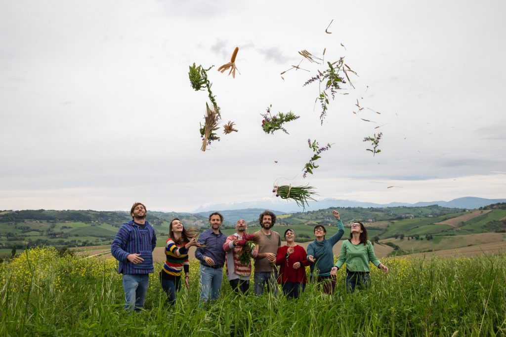 Foto di gruppo di persone che lanciano in aria ortaggi raccolti